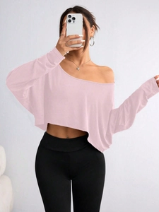 Detail of pink off-shoulder long sleeve crop top in a ribbed knit fabric mirror selfie