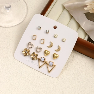 Macro shot of assorted gold stud earrings with rhinestones and marble on display card