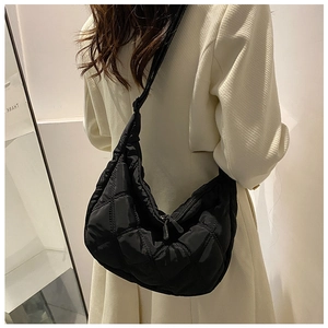 Detail of black quilted diamond stitch hobo bag with adjustable strap and double zipper