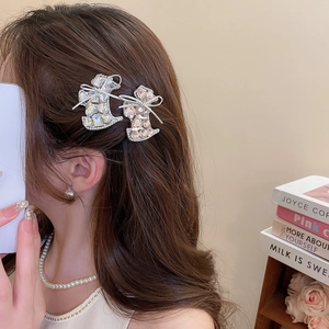 Macro detail of cat-shaped hair clips with sparkling crystals and silver bows on a model