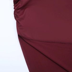 Detailed close-up of wine red knit dress featuring elegant side ruching and side split design