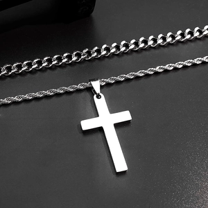 Macro detail of silver stainless steel cross pendant with rope chain and cuban link necklaces
