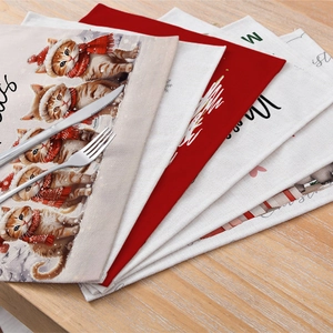 Linen Christmas placemats with cat patterns and Merry Christmas text on wooden table