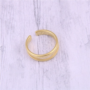 Detailed top view of a golden double-layered adjustable open ring on wooden surface