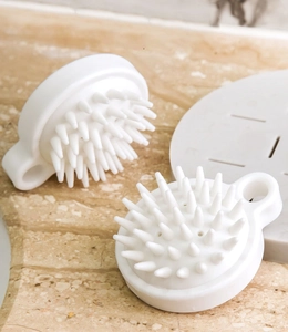 Detail showing white silicone scalp massager brushes with conical bristles and loop handle