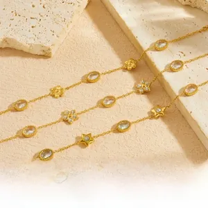 Detail of gold-plated bracelets featuring flower, star charms and oval zircon stones