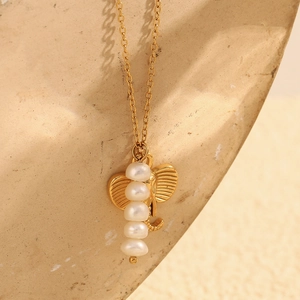 Detail of 18K gold plated elephant pendant necklace with white pearl trunk on stone