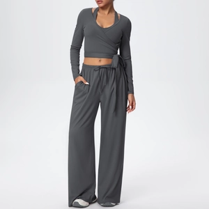 Détail de l'ensemble de yoga gris foncé avec haut croisé et pantalon large à cordon