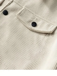 Makroaufnahme der Cord-Struktur und Brusttasche mit Knopf am beigen Langarmhemd
