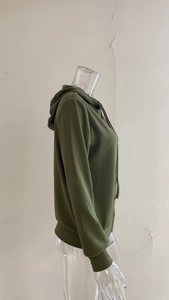 Dettaglio della trama in maglia a coste verde oliva di un maglione con cappuccio a maniche lunghe