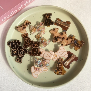 Variety set of cartoon bear and rabbit resin hair clips on a green speckled plate
