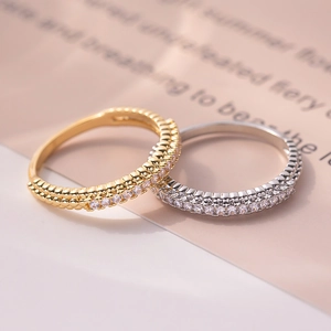 Macro view of gold and silver double-row micro-pave eternity rings with zircon stones