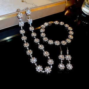 Close-up of sparkling rhinestone jewelry set including necklace and earrings on black surface