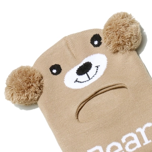 Macro detail of khaki bear balaclava knit hat showing texture and plush pom-poms