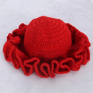 Detailed texture of red knitted hat with wide ruffled wavy edges for winter fashion