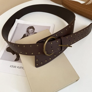 Close-up of brown leather belt with gold metal rivets and a vintage round pin buckle