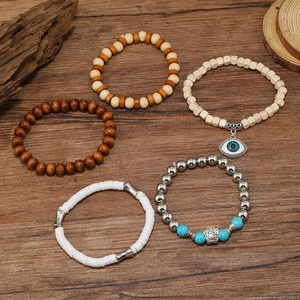 Detail of five handmade beaded bracelets featuring evil eye and paw print charms