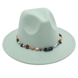 Detail of mint green wool fedora hat featuring a beaded bohemian style ethnic band