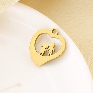 Golden heart pendant with boy and girl figures on white ceramic plate and beige fabric