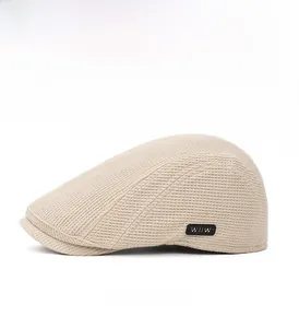 Vue latérale de la casquette beige avec texture gaufrée et emblème noir latéral