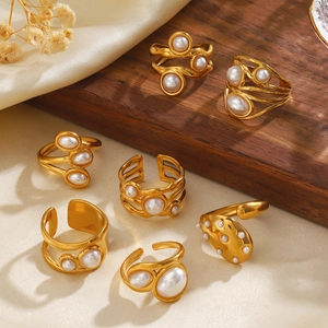 Luxurious gold-plated titanium steel pearl rings displayed on elegant silk fabric