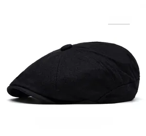 Detail of black wool flat cap featuring six-panel construction and short brim