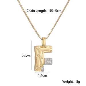 Detail of two-tone gold letter F pendant with dimensions 2.6cm by 1.4cm on chain