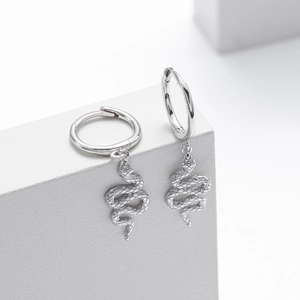 Macro detail of the silver snake drop earrings showing detailed scales and sleek texture
