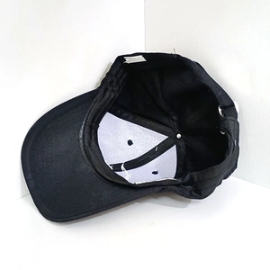 Detail view of black baseball cap interior with cotton sweatband and metal buckle closure