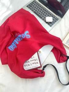 Détail du sac cabas rouge en tissu crépon avec une grande capacité pour ranger des livres