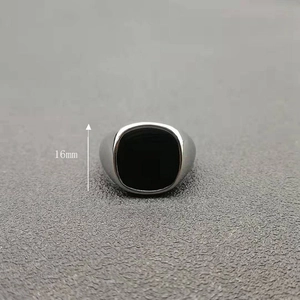 Detail view of a men's silver square signet ring with black enamel and 16mm height