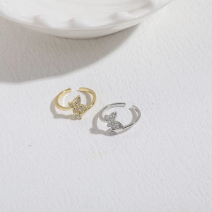 Detail of 14K gold and silver butterfly rings with micro-set cubic zirconia stones