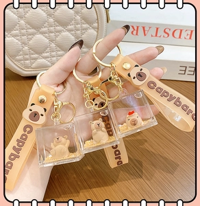 Close-up of liquid-filled capybara keychain with silicone wristband and golden hardware