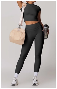 Dettaglio del set da yoga nero a vita alta con leggings, top e accessori fitness