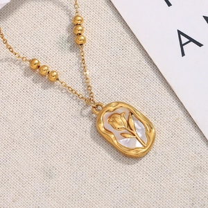 Detail of 18K gold plated sun rose pendant with white shell inlay on beaded chain