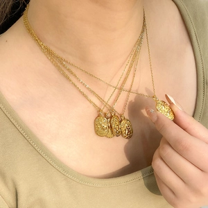 Lussuosa collana con ciondolo zodiacale quadrato dorato con strass scintillanti su modella