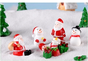 Detail view of miniature Santa, snowman, and gift boxes in a snowy Christmas scene