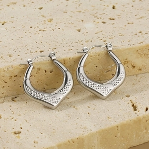 Silver geometric U-shaped earrings with textured diamond pattern on natural stone base