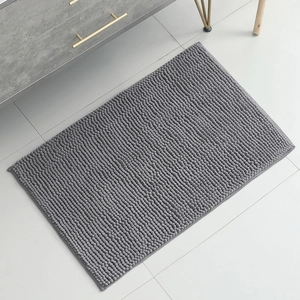 Macro shot of grey rectangular chenille bath mat showing soft fiber textures on tile