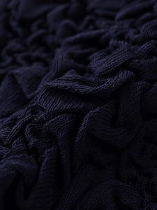 Detail shot of navy blue popcorn knit fabric with rich 3D texture and soft finish