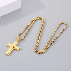 Close-up of golden stainless steel double-layered cross pendant with mirror finish and box chain