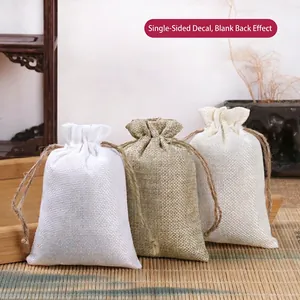 Linen drawstring jewelry pouches in white and beige on a wooden tray set