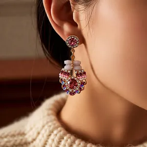 Vintage style gold earrings with purple crystals and intricate hollow metalwork