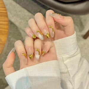 Faux ongles amande avec pointes françaises dorées et accents de relief dorés