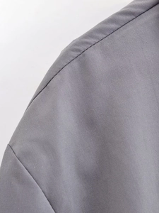 Detailed macro view of the grey shirt sleeve stitching and fine plain weave fabric texture