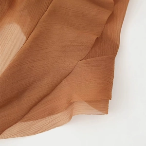 Robe en mousseline plissée marron avec couches asymétriques et détails transparents