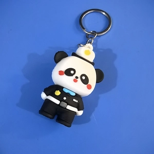 Close-up of cute panda keychain in police uniform with metal ring on blue background