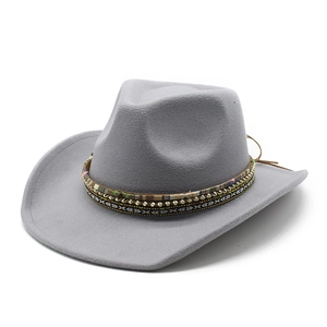 Détail d'un chapeau de cow-boy gris avec bande ethnique, perles dorées et cordon