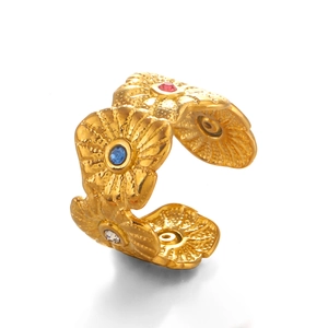 Golden flower ring with colorful crystals and radial petal texture on white background