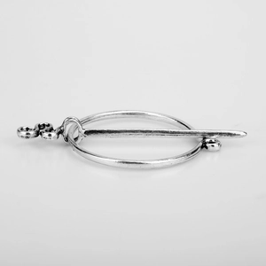 Detailed view of vintage silver Viking brooch pin with curved metal needle design